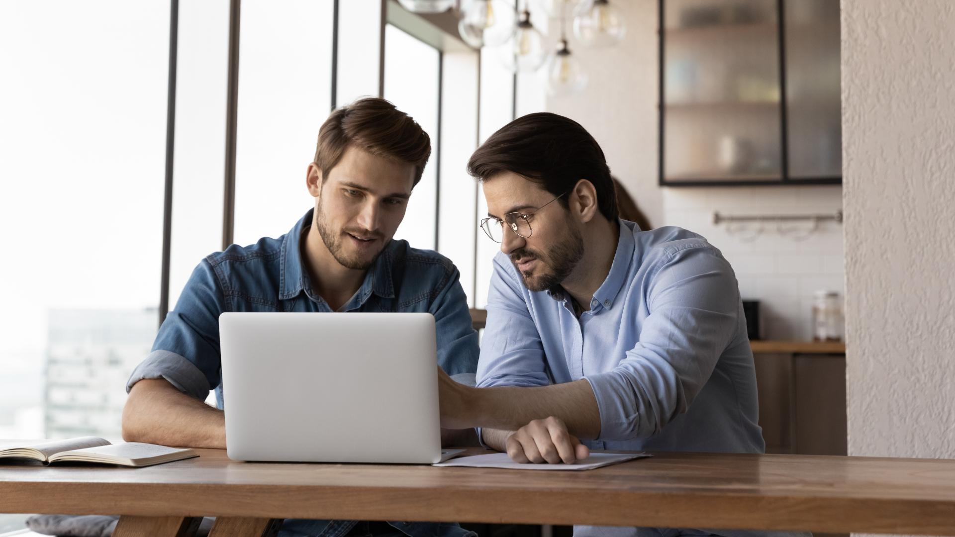 Professionals meeting while working on a laptop